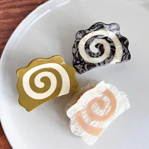 Three-piece acetate spiral shark hair clips in olive, ink marble, and cream stone patterns