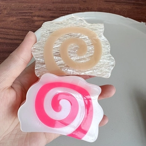 Handheld view of creative spiral acetate hair claws inspired by Japanese narutomaki fish cakes