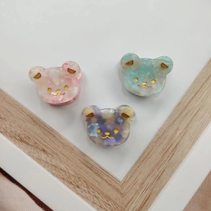 Cute bear-shaped acetate hair clips in pink and blue displayed on a white surface