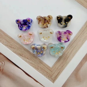 Set of 8 colorful bear-shaped acetate hair clips with marble texture in a tray