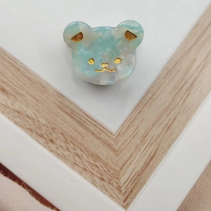 Detailed macro view of the mini light blue acetate bear hair claw with golden accents