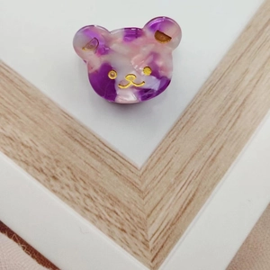 Detail of cute purple marble bear claw clip with gold accents and acetate texture