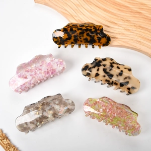 Set of five 13cm acetate hair claws in leopard, marble, and floral prints on a tray