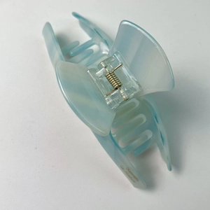 Détail d'une grande pince à cheveux bleu clair marbré avec texte Barrette La France doré