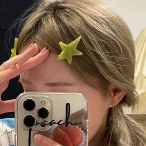 Green translucent acetate star hair clip worn by a model in a mirror selfie style shot