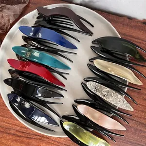 Polished colorful acetate hair clips in a radiating arrangement on a white tray