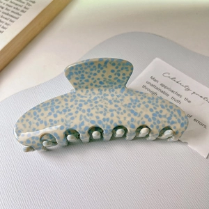 Detailed macro view of the acetate hair claw clip featuring a blue and white mottled pattern