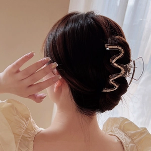 Pince à cheveux ondulée scintillante pour chignon de femme dans un intérieur élégant