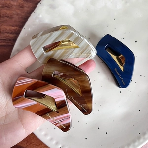 Set of four tortoiseshell acetate hair claws in marble and amber with metal clips
