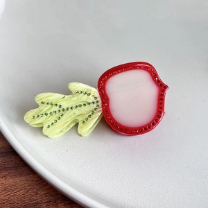 Dettaglio della pinza per capelli a forma di carota in acetato con strass scintillanti