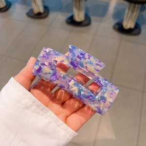 Macro shot of rectangular acetate hair claw with purple marble texture and spring