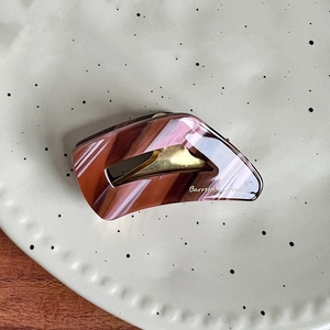 Close-up of marble pattern acetate hair claw clip with golden metal and France lettering