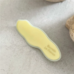 Dettaglio del fermaglio in acetato giallo chiaro con testo Barrette La France inciso