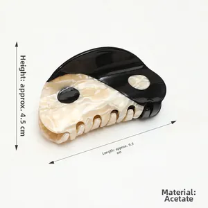 Detail showing yin yang acetate hair claw clip, 9.5cm length and 4.5cm height dimensions