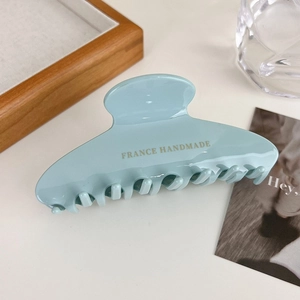 Detailed macro view of mint blue acetate hair claw clip with France Handmade gold text