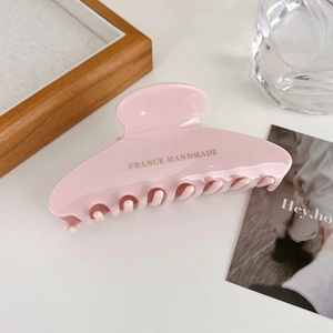 Detail of pink acetate hair claw clip with gold France Handmade logo engraving