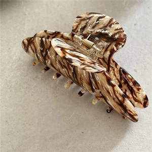 Détail du ressort métallique sur la pince à cheveux en acétate à motif de marbre