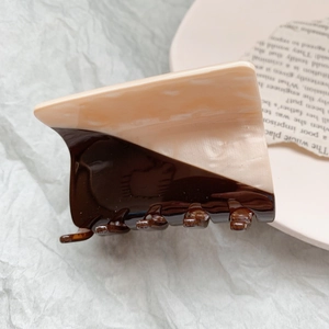 Macro view of large acetate claw clip with cream and coffee brown dual-tone design