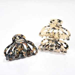 Detail of two tortoise shell hair claws featuring high-gloss acetate and hollowed design