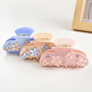 Detailed set of three floral hair claws in blue, apricot, and pink with sparkling rhinestones