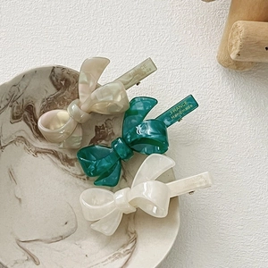 Three-piece acetate bow hair clip set in green and white with gold handmade engraving