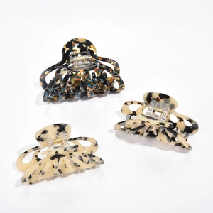 Macro shot of retro marble patterned acetate hair claws with hollow design and metal spring