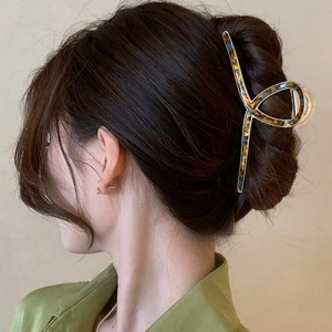 Detail view of large acetate metal hair claw clip holding a thick French twist hairstyle