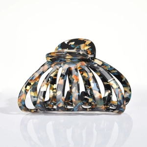 Close-up of multicolored acetate hair claw clip with tortoise pattern and metal spring