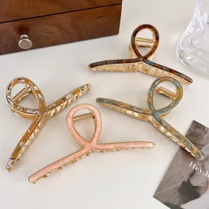 Set of four large acetate alloy hair claws in tortoise, marble, and pearlescent finishes