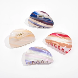 Set of four large acetate hair claw clips with marble textures and golden metal springs