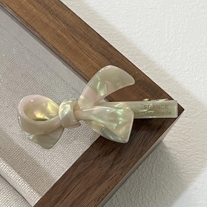 Detailed macro view of the France Handmade engraving on the creamy white acetate bow clip