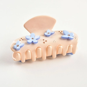 Detailed side view of peach resin hair claw clip with blue flowers and crystal embellishments