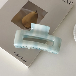 Detail of blue and white marble acetate hair claw clip with France Handmade text