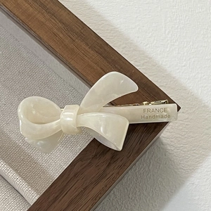 Close-up of cream marble acetic bow hair clip with FRANCE Handmade engraving