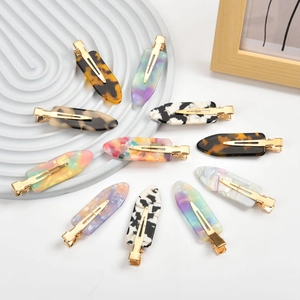 Flat lay of 11 assorted acetate hair clips with retro marble and tortoiseshell patterns