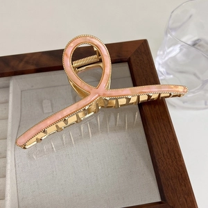 Close-up of pink marble acetate inlay on gold metal hair claw clip with elegant lines