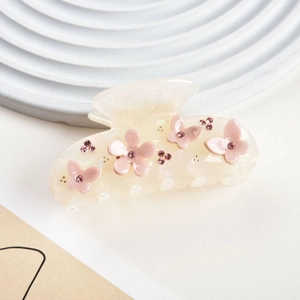 Close-up of cream floral hair claw clip with pink resin flowers and sparkling rhinestones