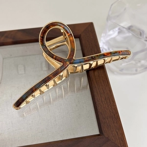 Detail of a large gold alloy hair claw clip with elegant tortoise shell resin inlay design