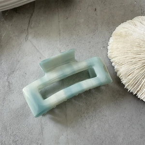 Detailed view of handmade rectangle acetate hair claw with blue marble texture