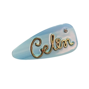 Graziosa clip per capelli in acetato azzurro con lettera Celin dorata e strass