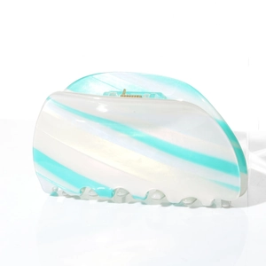 Detail of green striped acetate hair claw clip with pearl texture and metal spring