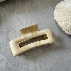 Macro detail of cream acetate hair claw clip featuring France Handmade engraving