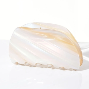 Macro detail of the acetate hair claw clip showing creamy pearlescent marble texture
