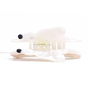 Macro view of white acetate hair claw with cute ghost design and gold metal spring