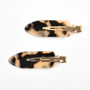 Close-up of a tortoiseshell patterned hair clip set with gold-colored metal duckbill clips