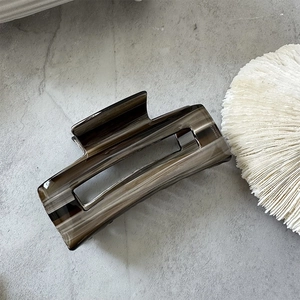 Detailed close-up of a marbled acetate hair claw clip featuring France Handmade text