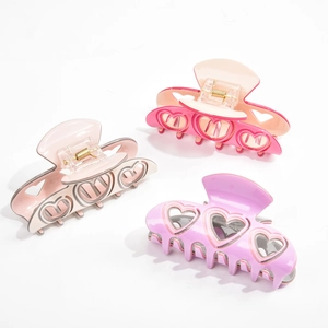 Lot de trois pinces à cheveux creuses en forme de cœur rose et violet présentées ensemble