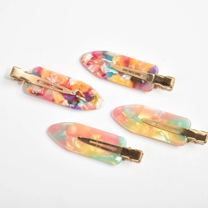 Set of four geometric acetate hair clips with colorful marble texture and golden metal base