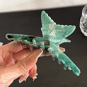 Détail de la pince à cheveux papillon en acétate avec marbre vert et motifs quadrillés