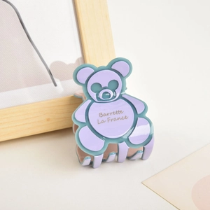Détail de la pince à cheveux ours en acétate violet et cyan avec lettrage doré Barrette La France
